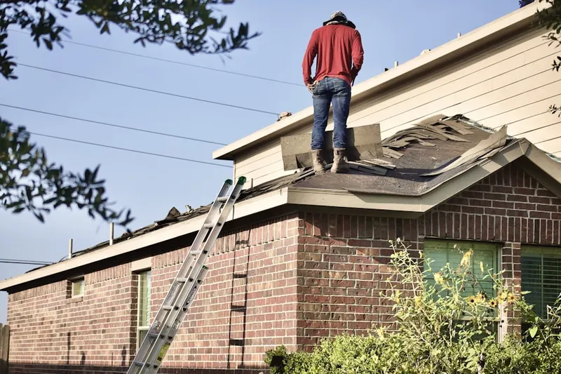 Professional roofer working on a residential roof in Tessman